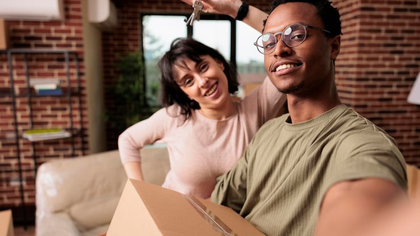 Happy first-time homebuyers receiving keys to their new condo